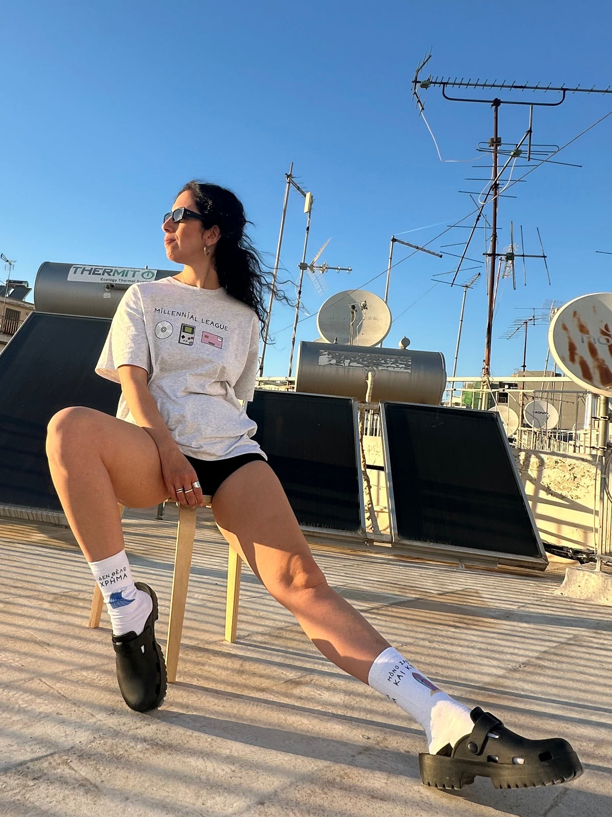 Person posing on a rooftop with antennas and satellite dishes in the background