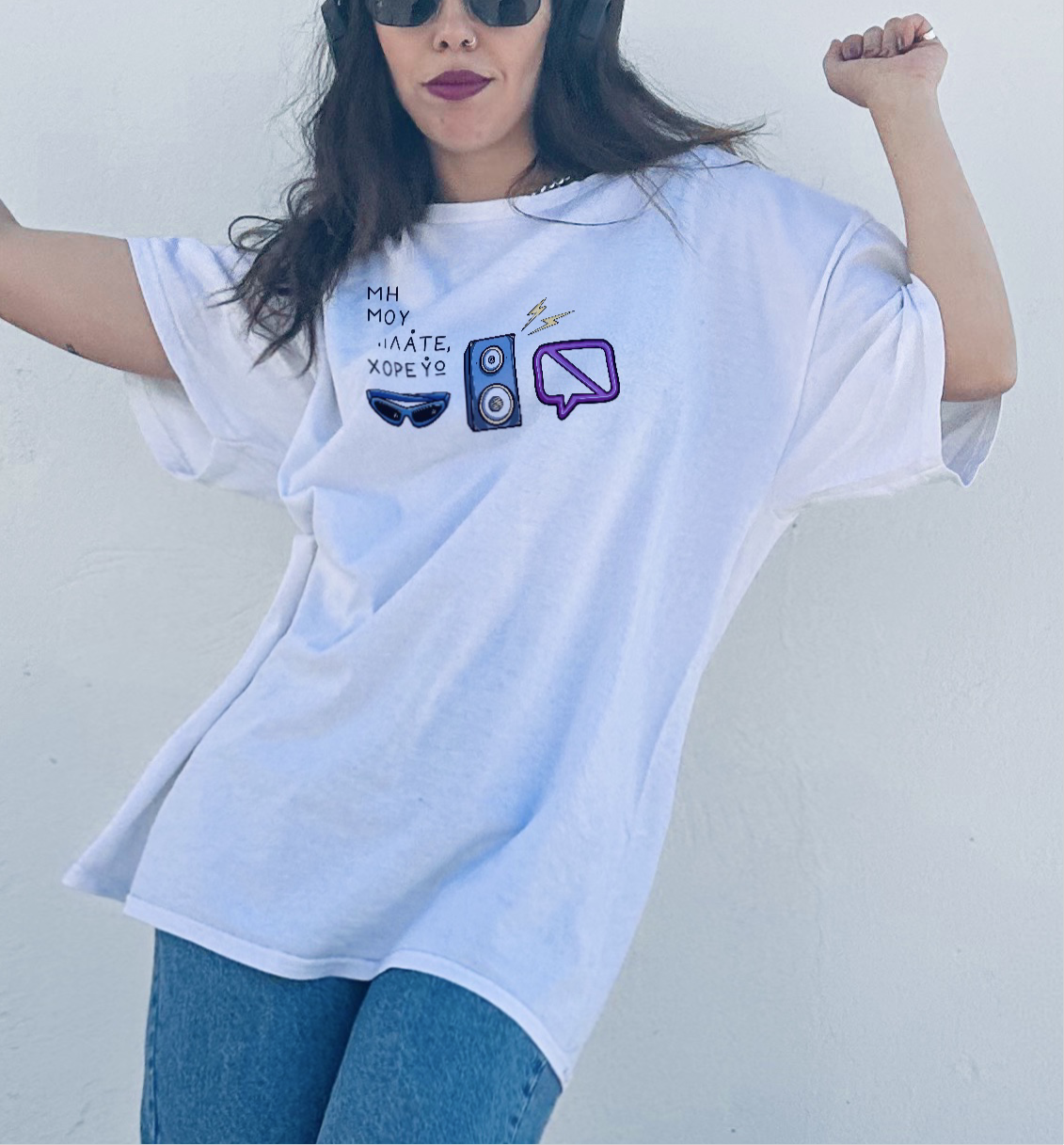 A person wearing a white crew neck t-shirt with a digital print that includes text and illustrations related to music and technology.