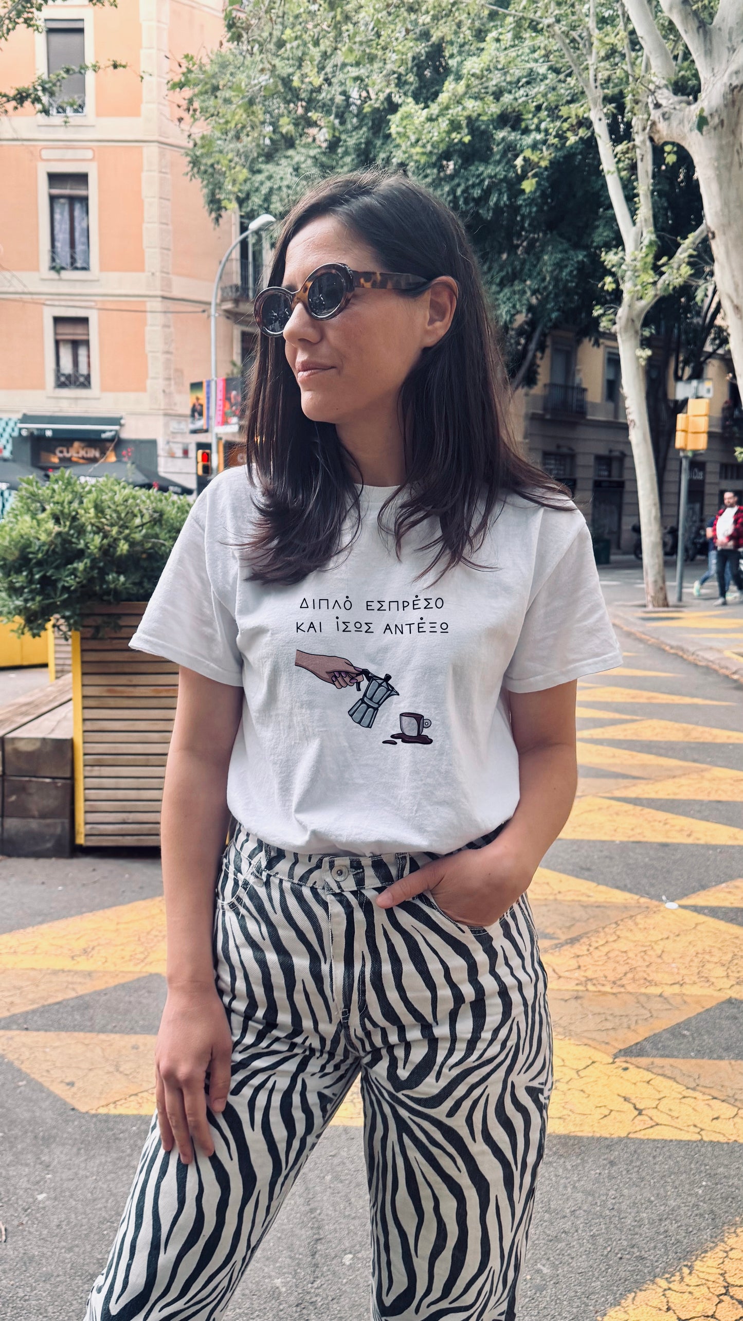 Woman wearing a white t-shirt with a graphic design on a city street.
