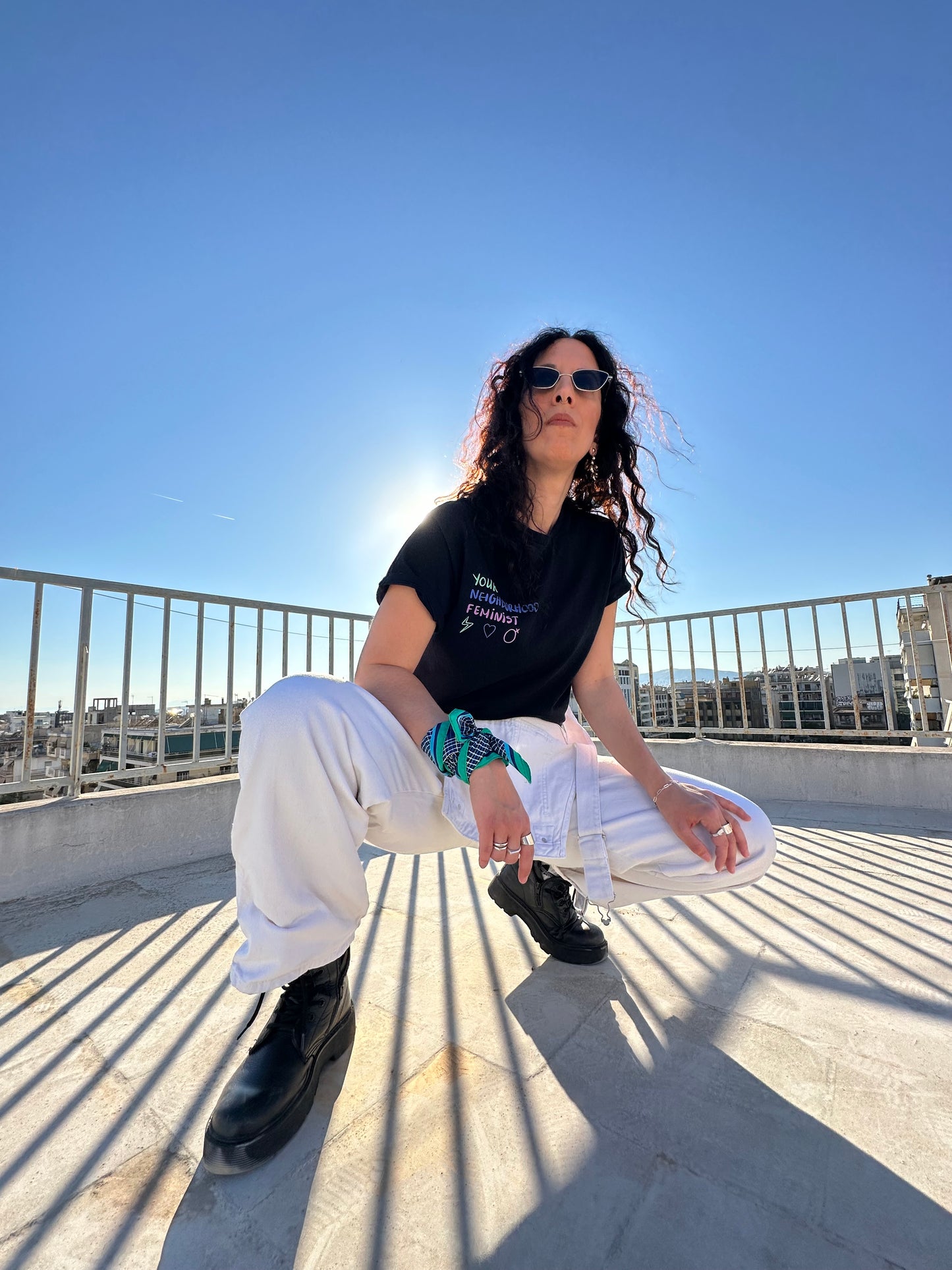 Person standing on a rooftop with a clear blue sky