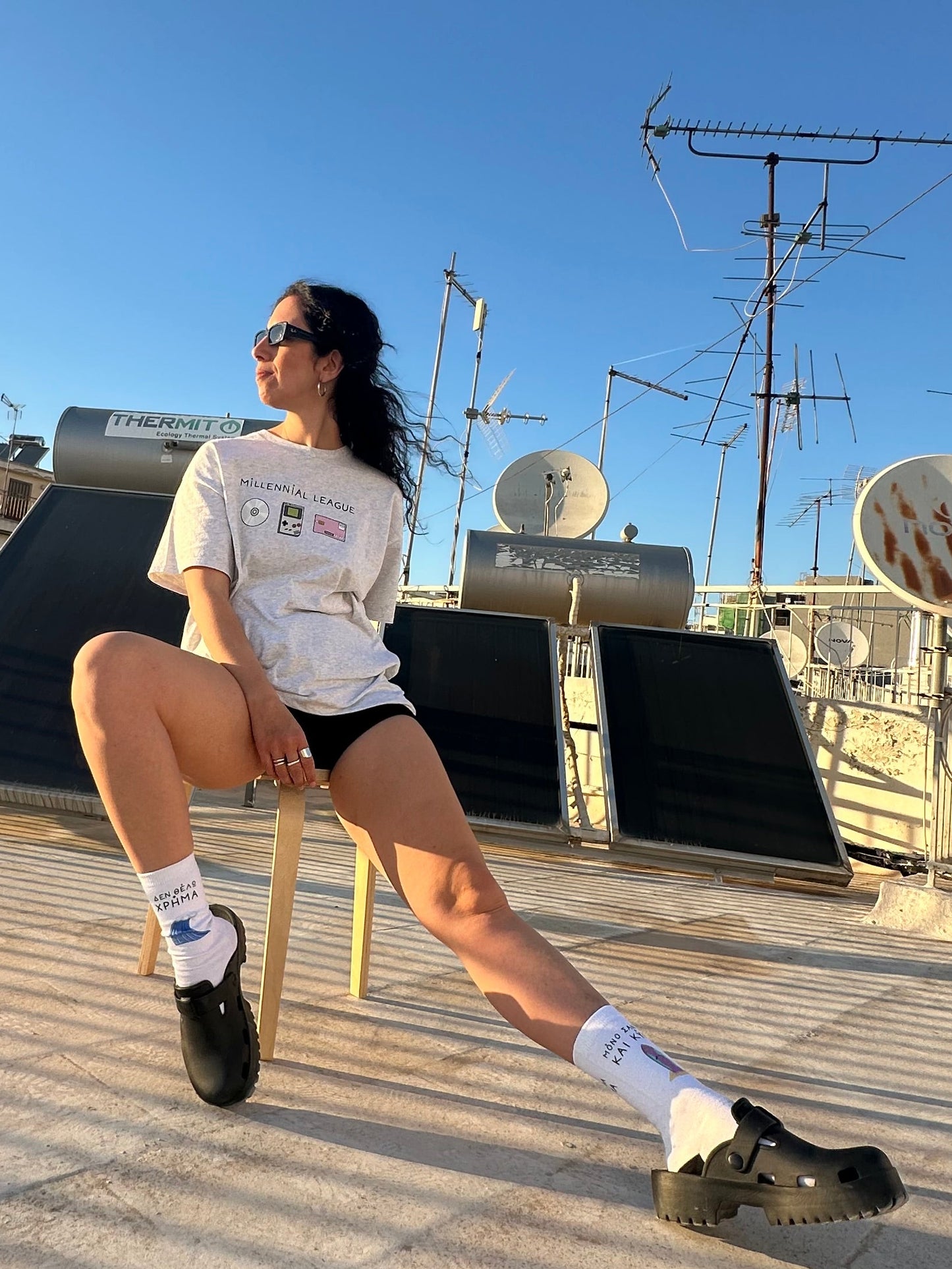 Person posing on a rooftop with antennas and satellite dishes in the background