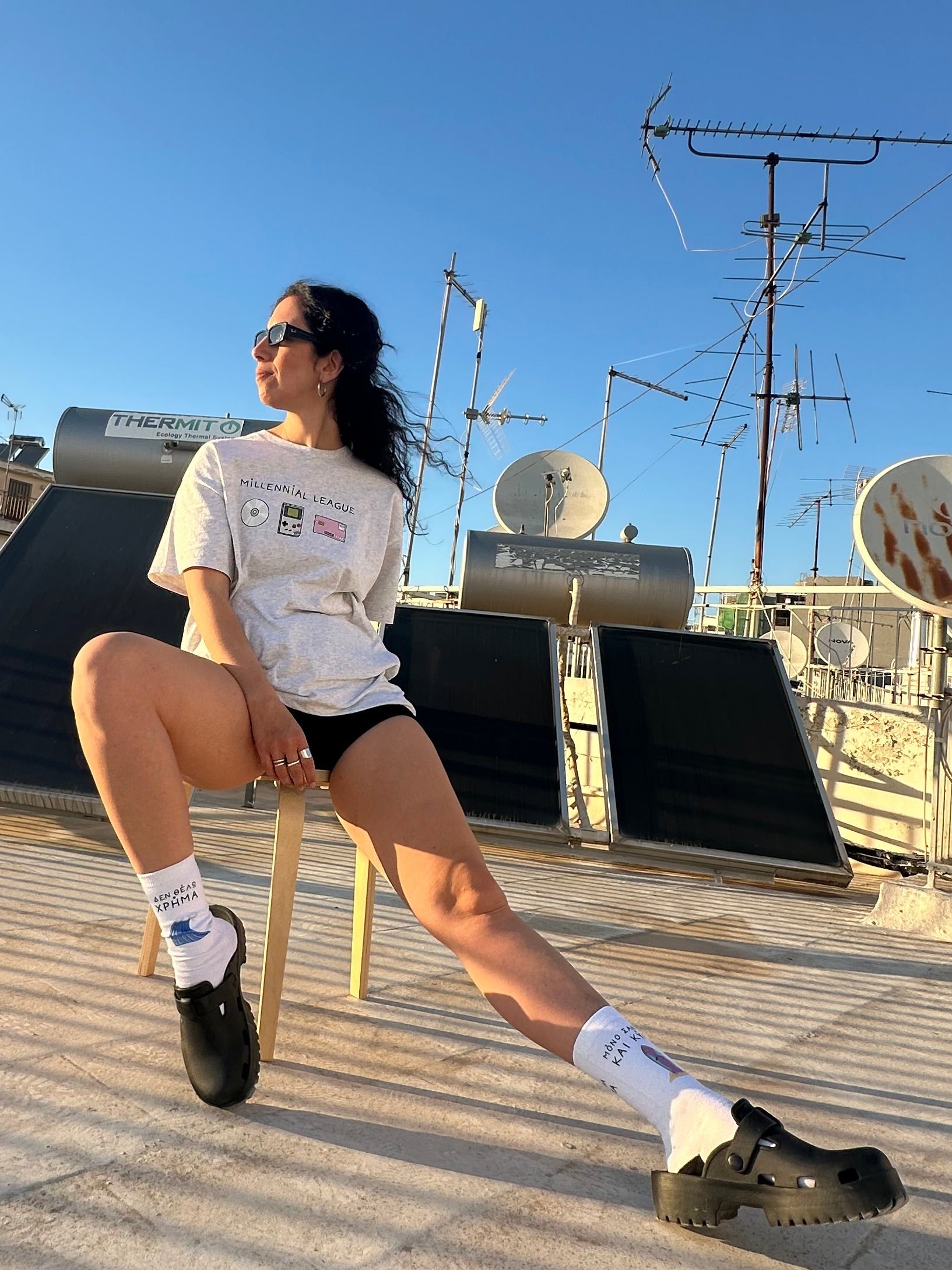 Person posing on a rooftop with antennas and satellite dishes in the background